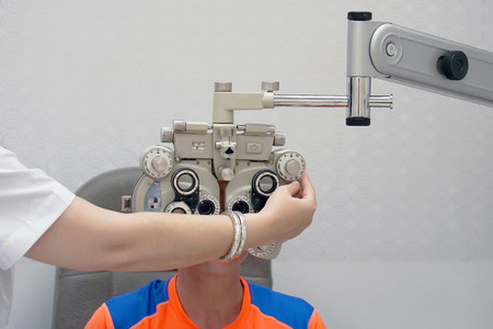 Female ophthalmologist examining patient man with optometrist trial frame. Male patient to check vision in ophthalmological clinicの写真素材