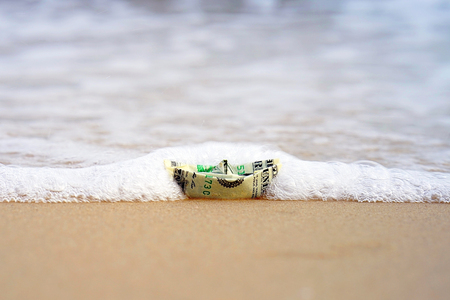 A boat made out of paper in the sea. Sea sand. Concept for the dollar.Copy spaceの写真素材