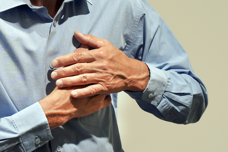 Aged pensioner having pain in his chest in home. Mature man suffering from pain at homeの写真素材