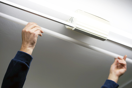 Electric hands changing ceiling fluorescent lamp. The concept of repair and service.の写真素材