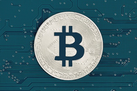 Bitcoin on dark grey circuit board. Bitcoin cryptocurrency on computer electronic circuit board. Cybercrime backgroundの写真素材