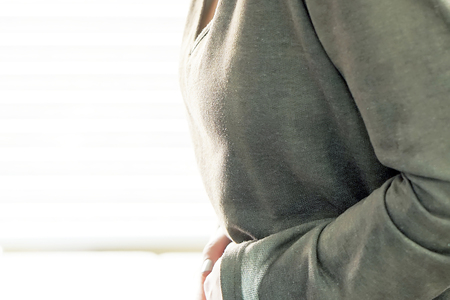 Close-up view of woman having painful stomachache at home. Chronic gastritis. Body And Health Care Concept.の写真素材