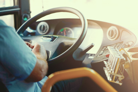 Hands of driver in a modern bus by driving. Concept of bus driver steering wheel and driving...