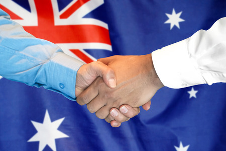 Business handshake on Australia flag background. Men shaking hands and Australia flag on background. Support conceptの写真素材