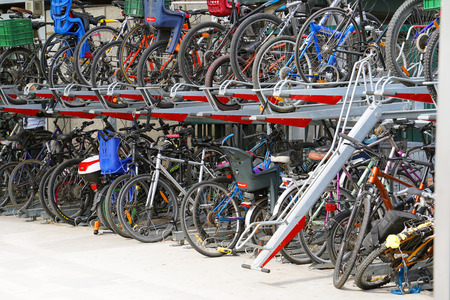 Parking for bicycles. Plenty bicycles at parking lot. Lots of bicycles in the parking lot. 11...
