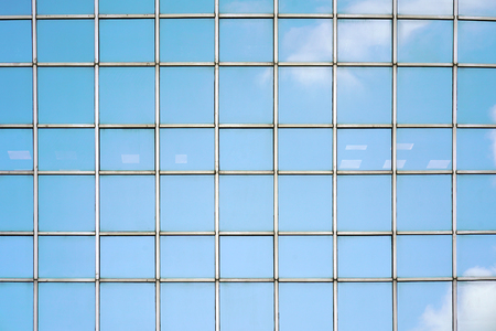 Glass blue Windows of facade modern city business building skyscraper. Modern apartment buildings in new neighborhood. Windows of a building, texture.の写真素材