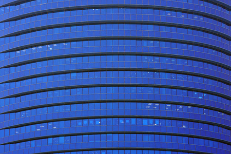 Glass blue square Windows of facade modern city business building skyscraper. Modern apartment buildings in new neighborhood. Windows of a building, texture.の写真素材