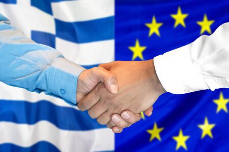 Business handshake on the background of two flags. Men handshake on the background of the Greece and European Union flag. Support conceptの写真素材
