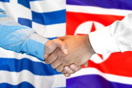 Business handshake on the background of two flags. Men handshake on the background of the Greece and North Korea flag. Support conceptの写真素材