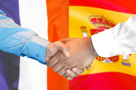 Business handshake on the background of two flags. Men handshake on the background of the France and Spain flag. Support conceptの写真素材