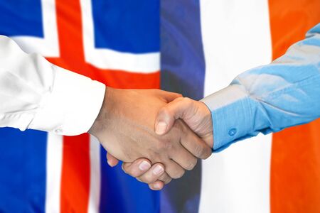 Business handshake on the background of two flags. Men handshake on the background of the Iceland and France flag. Support conceptの写真素材