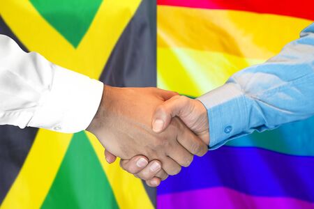 Business handshake on the background of two flags. Men handshake on the background of the Jamaica and LGBT gay flag. Support conceptの写真素材