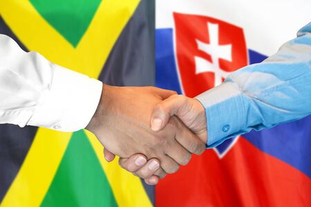 Business handshake on the background of two flags. Men handshake on the background of the Jamaica and Slovakia flag. Support conceptの写真素材
