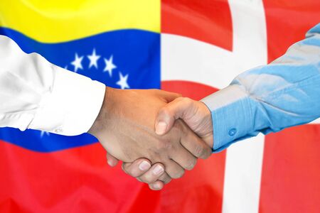 Business handshake on the background of two flags. Men handshake on the background of the Venezuela and Denmark flag. Support conceptの写真素材