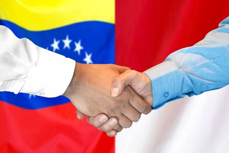 Business handshake on the background of two flags. Men handshake on the background of the Venezuela and Monaco flag. Support conceptの写真素材