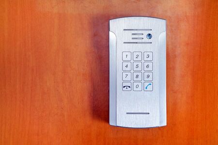 Secure password on keyboard for opening home house door on red wooden background. Password code Security keypad system protected in Public Building. The security code combination to unlock the doorの写真素材
