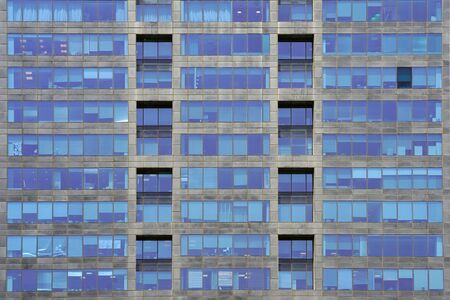 Glass gray and blue square Windows of modern city business building skyscraper. Glass balconies in the building. Modern apartment buildings in new neighborhood. Windows of a building, texture.の写真素材