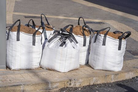 Large sandbags, construction materials for the work. Big sand bags were placed beside the road, Jumbo bags of sand are used for sandpits and under paving.の写真素材