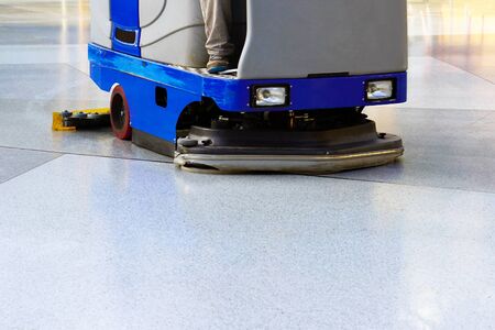 Man driving professional floor cleaning machine at airport or railway station or supermarket. Floor care and cleaning serviceの写真素材
