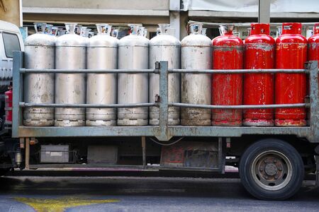 Truck with gas cylinders on the road. Many red and gray gas cylinders transported in car.の写真素材
