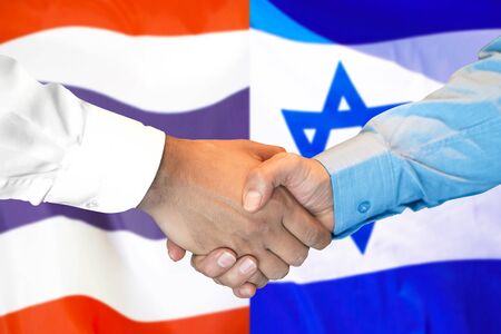 Business handshake on the background of two flags. Men handshake on the background of the Thailand and Israel flag. Support conceptの写真素材