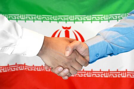 Business handshake on Iran flag background. Men shaking hands and Iran flag on background. Support conceptの写真素材