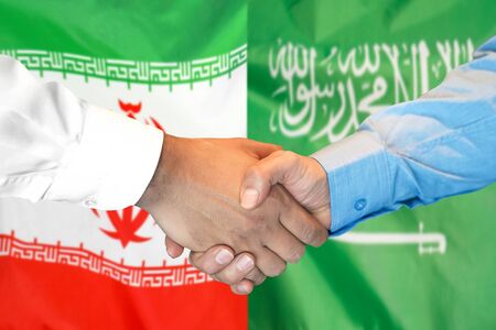 Business handshake on the background of two flags. Men handshake on the background of the Iran and Saudi Arabia flag. Support conceptの写真素材