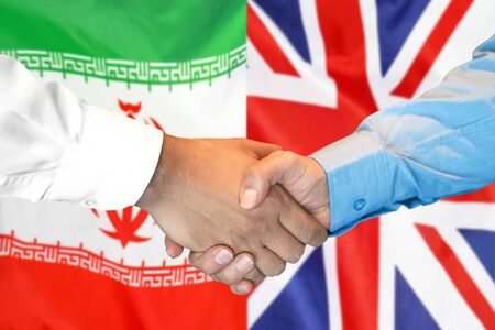 Business handshake on the background of two flags. Men handshake on the background of the Iran and United Kingdom flag. Support conceptの写真素材