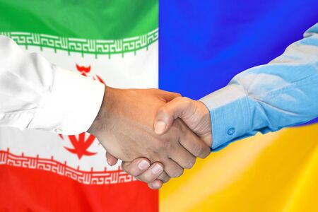 Business handshake on the background of two flags. Men handshake on the background of the Iran and Ukraine flag. Support conceptの写真素材