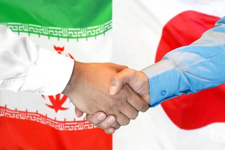 Business handshake on the background of two flags. Men handshake on the background of the Iran and Japan flag. Support conceptの写真素材