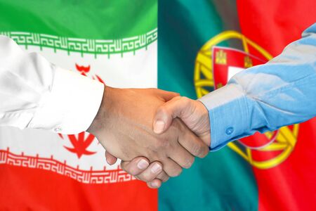 Business handshake on the background of two flags. Men handshake on the background of the Iran and Portugal flag. Support conceptの写真素材