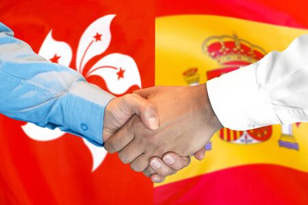 Business handshake on the background of two flags. Men handshake on the background of the Hong Kong and Spain flag. Support conceptの写真素材