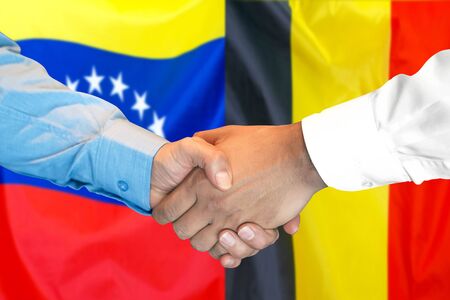 Business handshake on the background of two flags. Men handshake on the background of the Belgium and Venezuela flag. Support conceptの写真素材