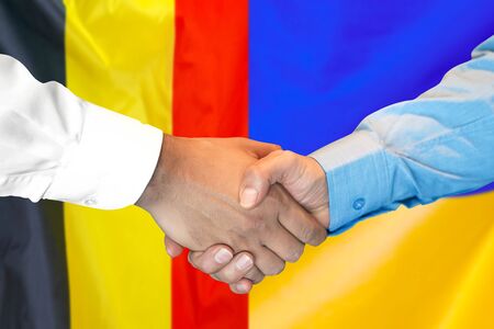Business handshake on the background of two flags. Men handshake on the background of the Belgium and Ukraine flag. Support conceptの写真素材