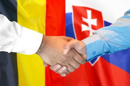 Business handshake on the background of two flags. Men handshake on the background of the Belgium and Slovakia flag. Support conceptの写真素材