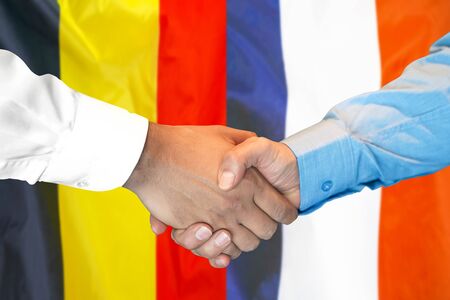 Business handshake on the background of two flags. Men handshake on the background of the Belgium and France flag. Support conceptの写真素材