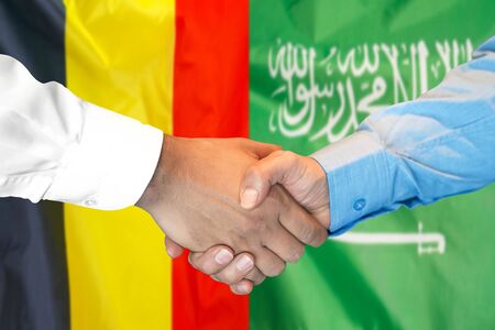 Business handshake on the background of two flags. Men handshake on the background of the Belgium and Saudi Arabia flag. Support conceptの写真素材