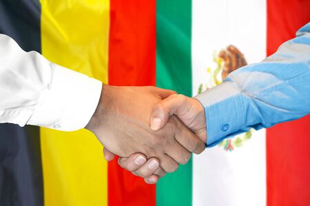 Business handshake on the background of two flags. Men handshake on the background of the Belgium and Mexico flag. Support conceptの写真素材
