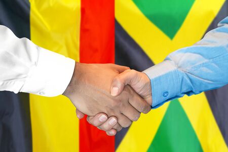 Business handshake on the background of two flags. Men handshake on the background of the Belgium and Jamaica flag. Support conceptの写真素材