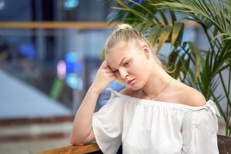 Lonely caucasian woman is sad. Portrait of a beautiful sad female close-up. Woman feel depression. Portrait of beautiful girl thinks over the problem. Face of serious young female. Portrait of pensive fair-haired dreamy hipster girl imagines something in her mind.の写真素材