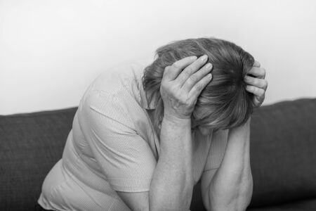 Black and white image of a elderly woman depression or domestic violence. People, grief and domestic violence concept. Close-up of unhappy crying elderly woman.の写真素材