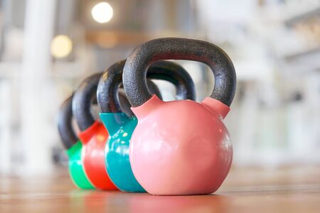 Colorful kettlebells in a row in a gym.の写真素材