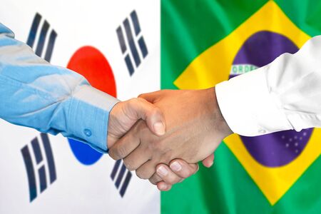 Business handshake on the background of two flags. Men handshake on the background of the South Korea and Brazil flag. Support conceptの写真素材