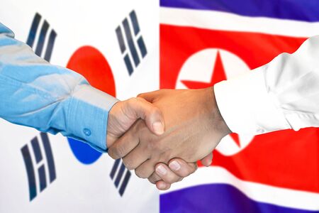 Business handshake on the background of two flags. Men handshake on the background of the South Korea and North Korea flag. Support conceptの写真素材
