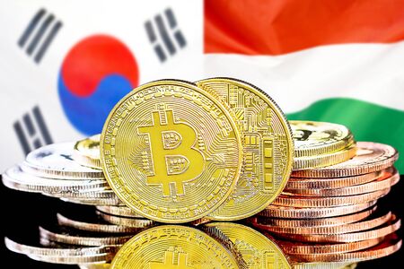 Concept for investors in cryptocurrency and Blockchain technology in the South Korea and Hungary. Bitcoins on the background of the flag South Korea and Hungary.の写真素材