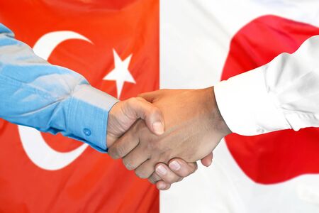 Business handshake on the background of two flags. Men handshake on the background of the Turkey and Japan flag. Support conceptの写真素材