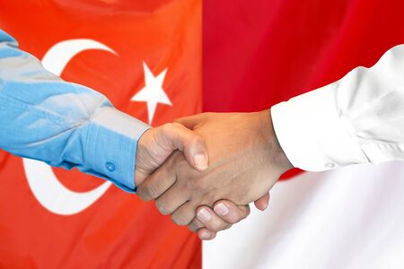 Business handshake on the background of two flags. Men handshake on the background of the Turkey and Monaco flag. Support conceptの写真素材