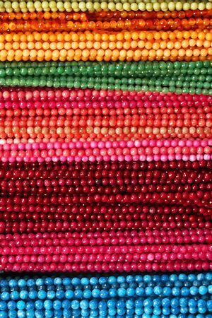 Colorful Beads Background. Background pattern of multicolored natural stone beads. String of beads in various colors. Colorful beads necklaces. Handicraft fashionable for womenの写真素材