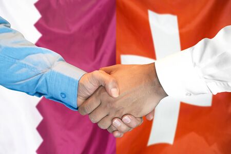 Business handshake on the background of two flags. Men handshake on the background of the Qatar and Switzerland flag. Support conceptの写真素材