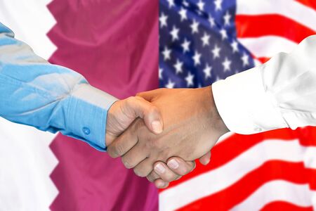 Business handshake on the background of two flags. Men handshake on the background of the Qatar and United States of America flag. Support conceptの写真素材
